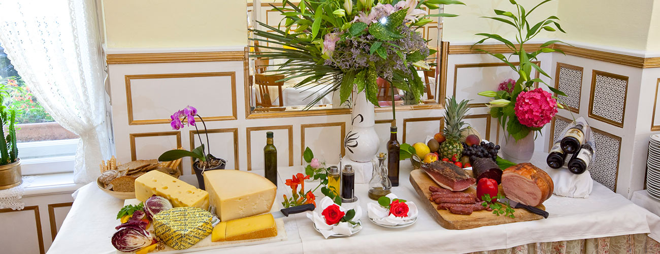 Buffet mit Wurstwaren und verschiedenen Käselaiben